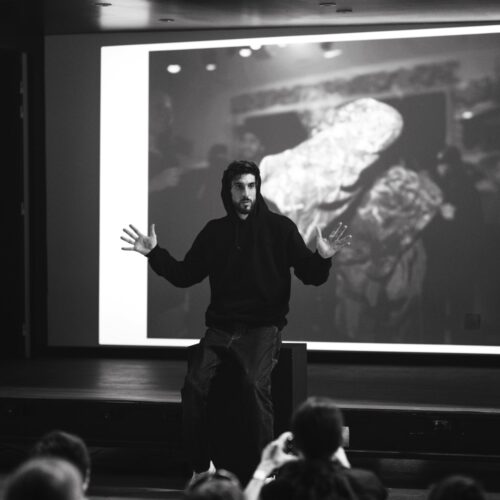 Photo en noir et blanc de l'artiste Timothée LeJolivet, en pleine prise de parole.