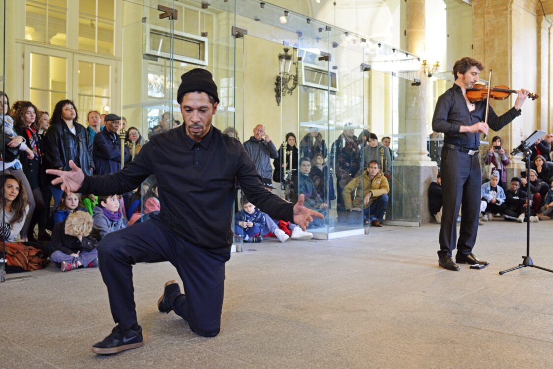 Danseur en mouvement, violoniste à côté avec spectateur en fond. Danseur en mouvement, violoniste à côté avec spectateur en fond.