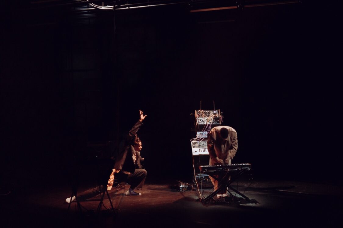 Un danseur en mouvement faisant face à un musicien jouant sur un piano électrique pour le spectacle Earthbound. Un danseur en mouvement faisant face à un musicien jouant sur un piano électrique pour le spectacle Earthbound.