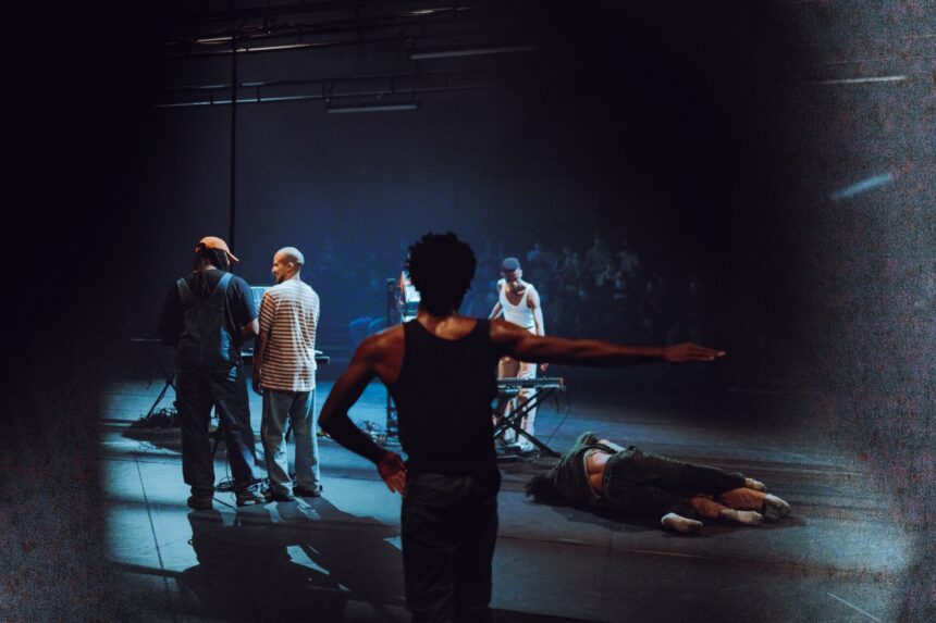 Danseur en mouvement au premier plan, danseurs, musicien et spectateur en fond