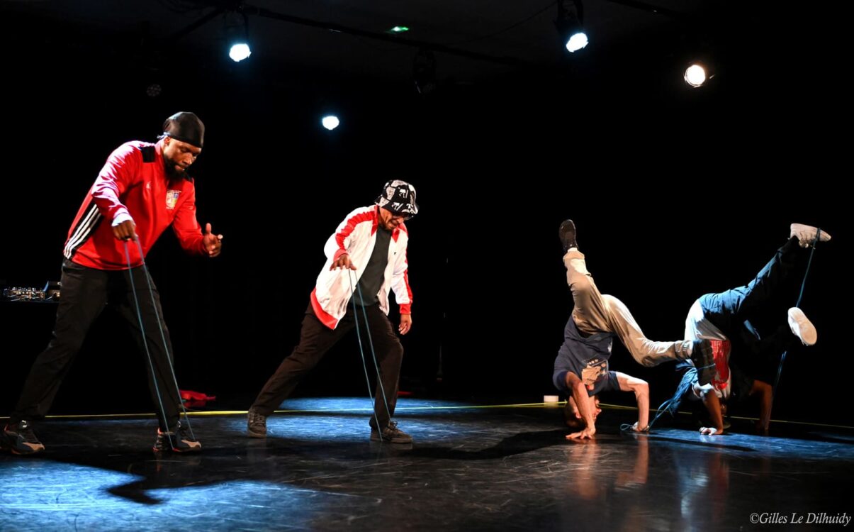 Danseurs en mouvement sur scène durant la performance J-2. Danseurs en mouvement sur scène durant la performance J-2.