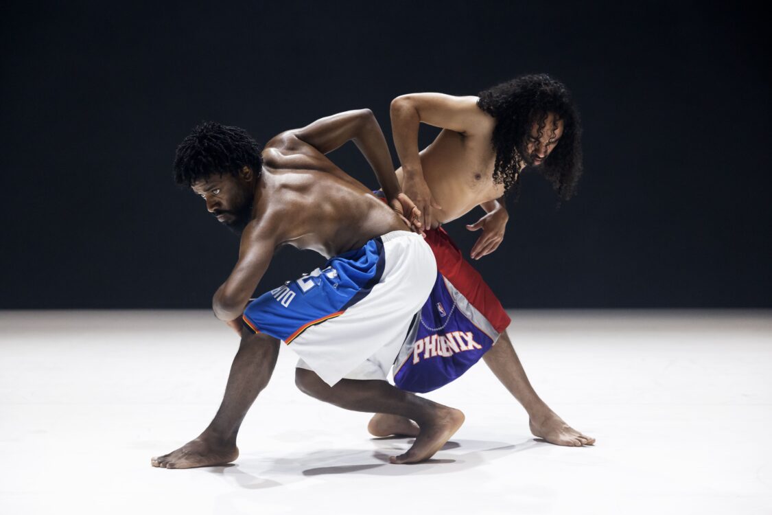 Deux danseurs en mouvement, leurs corps sont côte à côte un qui regarde droit devant lui. Deux danseurs en mouvement, leurs corps sont côte à côte un qui regarde droit devant lui.