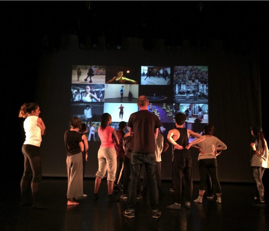 Danseur tourné vers un écran pour le spectacle Post Danse. Danseur tourné vers un écran pour le spectacle Post Danse.