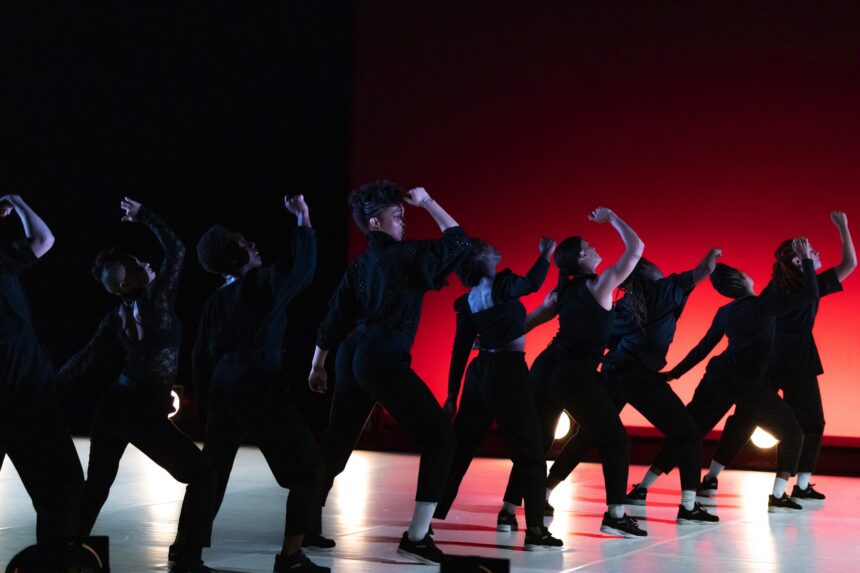 Danseuses sur scène, en mouvement. Le fond est rouge et elles sont en noir.