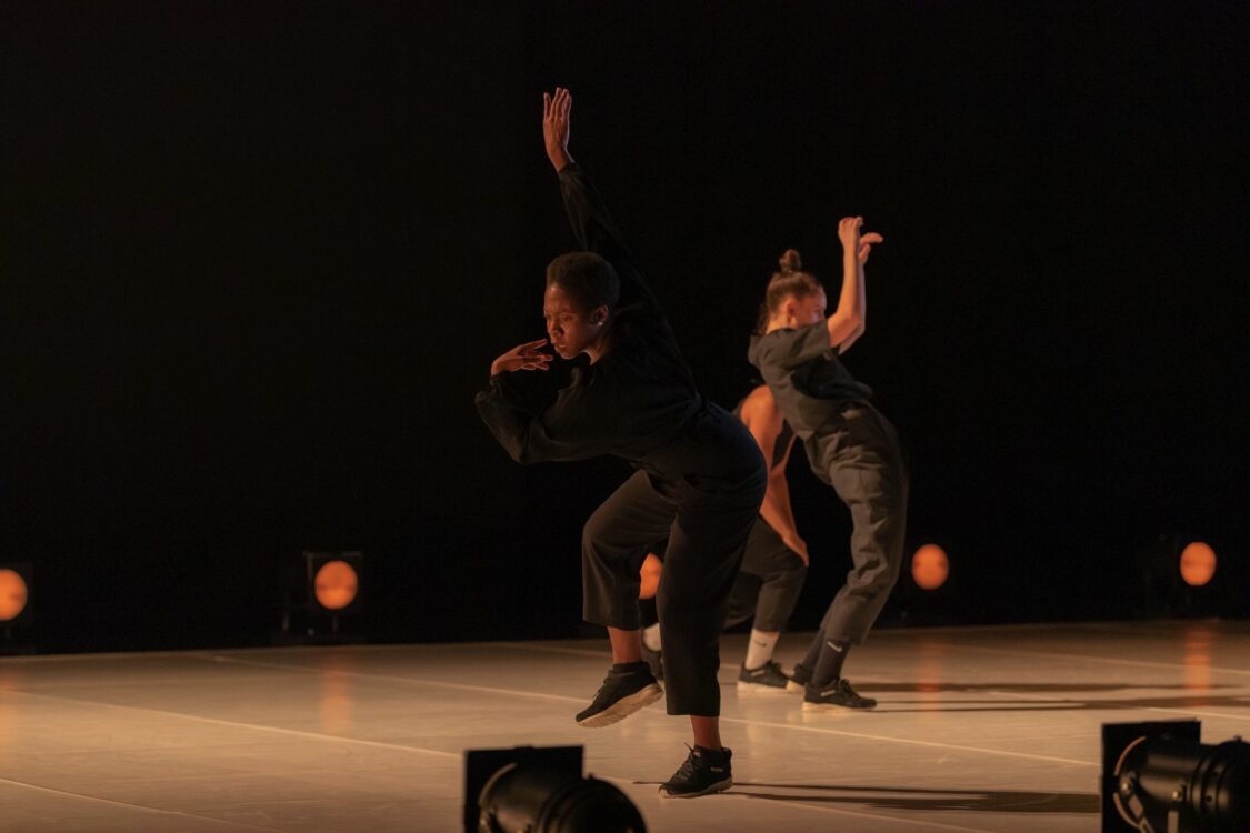 Danseuse en mouvement sur le devant de la scène. En fond, deux danseuses en mouvement. Danseuse en mouvement sur le devant de la scène. En fond, deux danseuses en mouvement.