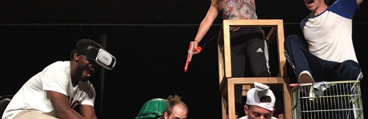 Plusieurs personnes su scène. Un avec casque VR, un avec une DS, un qui le regarde. Deux autres sont à côtés.