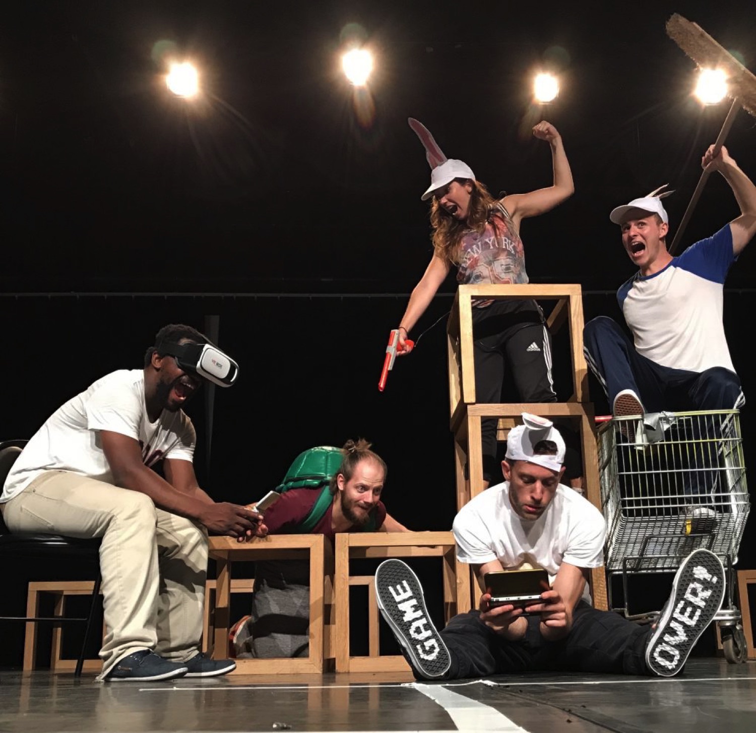 Plusieurs personnes su scène. Un avec casque VR, un avec une DS, un qui le regarde. Deux autres sont à côtés.