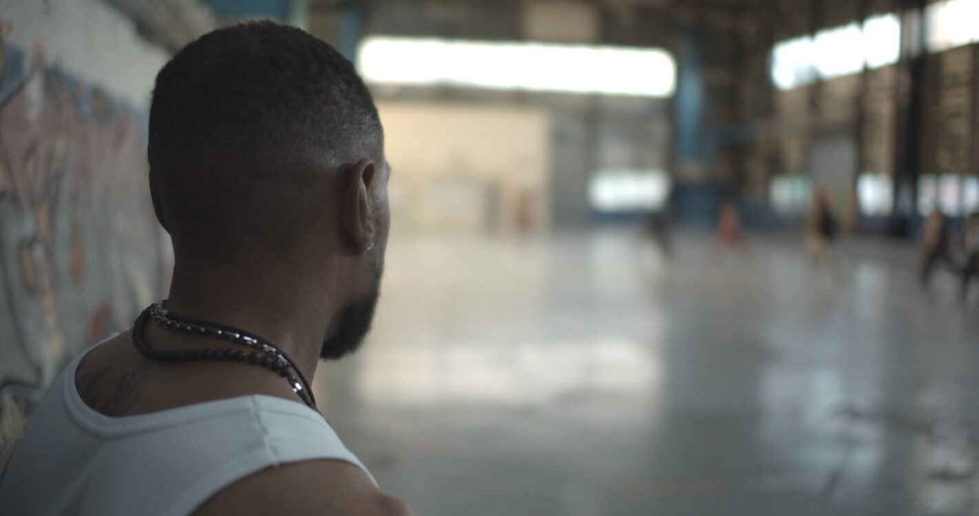 Premier plan rapproché sur un homme de dos faisant face à une salle de danse. Premier plan rapproché sur un homme de dos faisant face à une salle de danse.