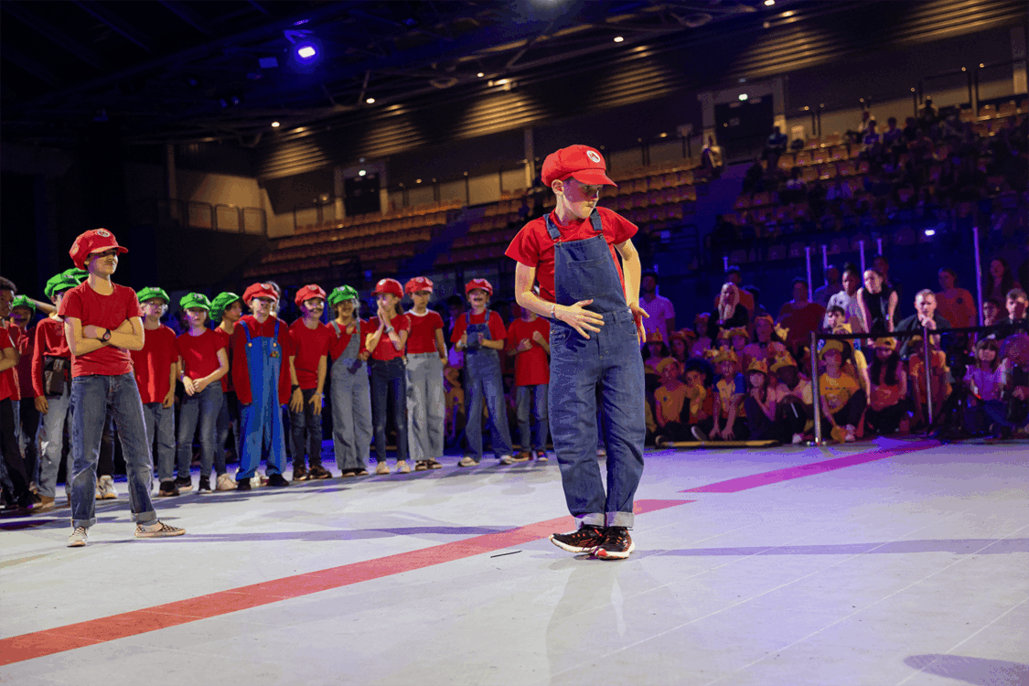 Photo d'un élève sur le devant de la scène, déguisé en mario. Sa classe en arrière plan.