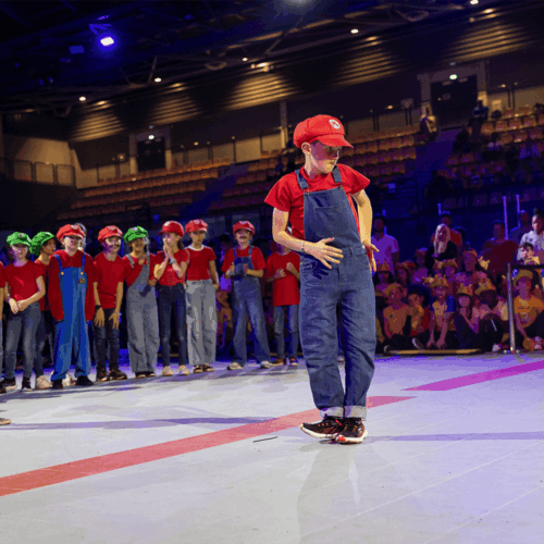 Photo d'un élève sur le devant de la scène, déguisé en mario. Sa classe en arrière plan.