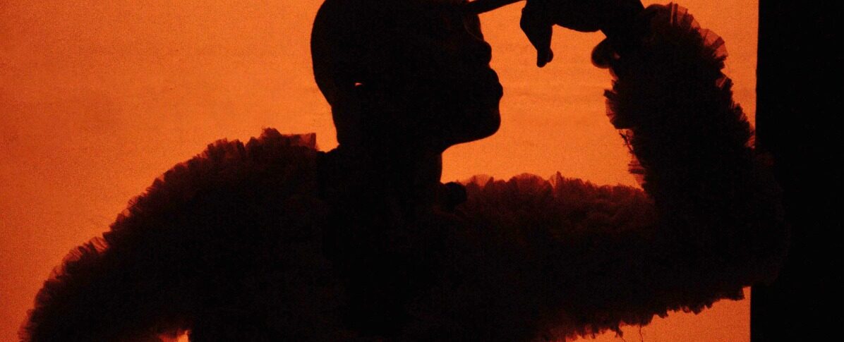 Photo d'une personne en mouvement. On ne la voit pas, seulement le fond orange.