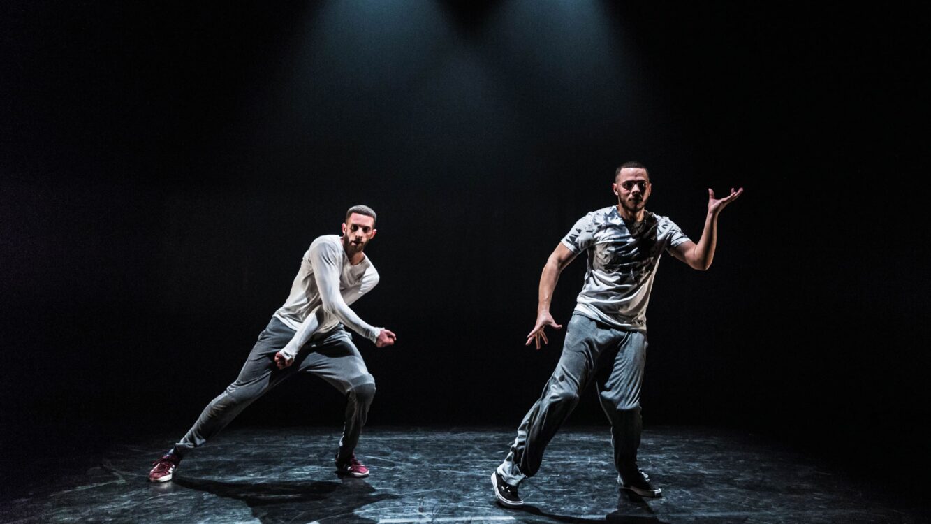 Photo de deux à danseurs en mouvement. À droite, Bouzid Ait Atmane.